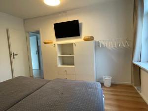a bedroom with a bed and a tv on a wall at Ostsee Ferienwohnung Pelzerhaken in Neustadt in Holstein