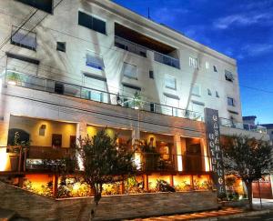 Un grand bâtiment blanc avec des lumières sur lui dans l'établissement Hotel CasaBlanca, à Águas de Lindóia