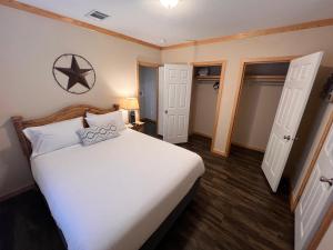 a bedroom with a large white bed and two doors at The Hideout Golf Club & Resort in Lake Brownwood +53 photos