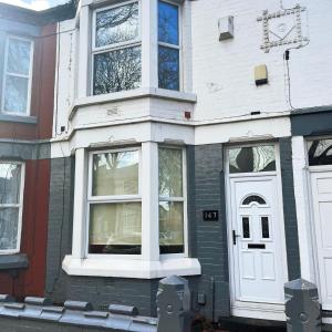 a house with a white door and windows at Rooms Anfield- 5 mins from LFC in Liverpool
