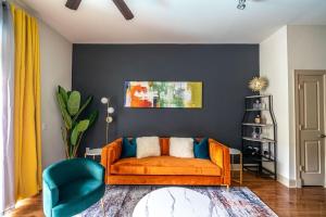 a living room with an orange couch and a blue chair at PackHouse NRG/MED Center in Houston