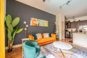 a living room with an orange couch and a table at PackHouse NRG/MED Center in Houston