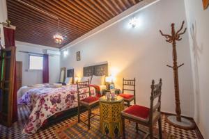 1 dormitorio con 1 cama, 2 sillas y mesa en Medina Sky en Fez