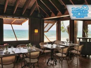 un comedor con mesas y sillas y el océano en KASA Seahorse of the Sea - Studio for 2 BEACH BLOCK en San Juan