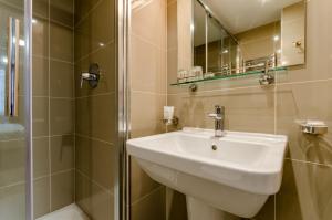 a bathroom with a sink and a shower at Royal Cambridge Hotel in London