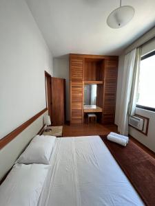 a bedroom with a large white bed and a desk at Locking's Funcionários 6 in Belo Horizonte