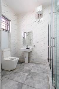 a white bathroom with a sink and a toilet at Cecilia Homes in Lekki