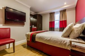 ロンドンにあるロイヤル ケンブリッジ ホテルのベッド1台、薄型テレビが備わるホテルルームです。