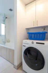 a washing machine with a bowl on top of it in a kitchen at Stunning Light-filled 2Bed w Car Park in Auckland