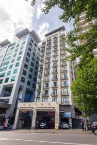 two tall white buildings next to a street at Stunning Light-filled 2Bed w Car Park in Auckland