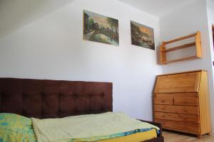 sypialnia z łóżkiem i drewnianą komodą w obiekcie Dom na Warmii w Lidzbarku Warmińskim
