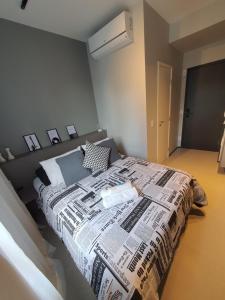 a bedroom with a bed covered in a newspaper at Studio Perdizes Allianz in São Paulo