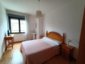 a bedroom with a bed and a desk and a window at Pension Paseo Real in Cangas de Onís