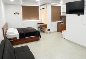 a bedroom with a bed and a tv in a room at Hotel El Faro Buga in Buga