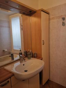 ein Badezimmer mit einem weißen Waschbecken und einem Spiegel in der Unterkunft Casa vacanze il Tuffetto in Olginate
