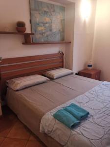 ein Schlafzimmer mit einem Bett mit einem grünen Handtuch darauf in der Unterkunft Casa vacanze il Tuffetto in Olginate