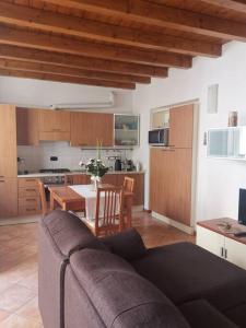 ein Wohnzimmer mit einem Sofa und einer Küche in der Unterkunft Casa vacanze il Tuffetto in Olginate