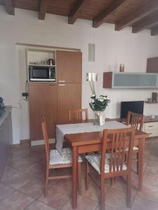 eine Küche mit einem Holztisch und Stühlen sowie eine Küche mit einer Mikrowelle in der Unterkunft Casa vacanze il Tuffetto in Olginate