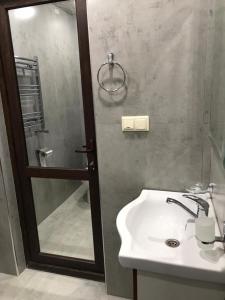 ein Bad mit einem Waschbecken und einer Dusche mit einem Spiegel in der Unterkunft David guest house LOFT Коттеджи на берегу реки in Dilidschan