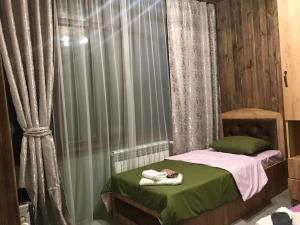 Un pequeño dormitorio con una cama con toallas. en David guest house LOFT Коттеджи на берегу реки, en Dilijan