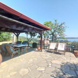 a patio with a table and chairs on a patio at Green & Blue House in Vourvourou