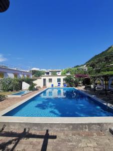 een groot zwembad met blauw water bij Residence Villa Olivia in Ischia