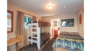 a bedroom with two bunk beds and a desk at Cabin 1 Lynn View Lodge in Haines