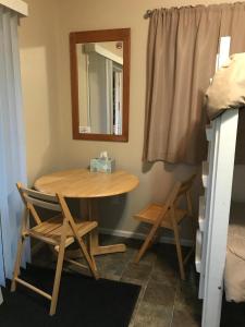 a table and chairs in a room with a mirror at Cabin 1 Lynn View Lodge in Haines