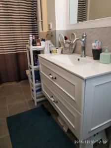 a bathroom vanity with a sink and a mirror at People LOVE this home! in Haifa