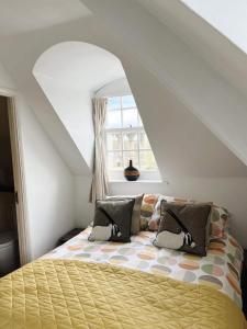 a bedroom with a yellow bed with a window at 4 bed loft apartment overlooking historic town in Trowbridge +9 photos