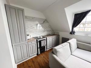 eine Küche mit Herd und Sofa in einem Zimmer in der Unterkunft 4 bed loft apartment overlooking historic town in Trowbridge