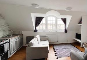 een woonkamer met een bank en een raam bij 4 bed loft apartment overlooking historic town in Trowbridge