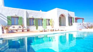 a villa with a swimming pool in front of a house at Villa Maria Paros - A Unique & Luxurious Villa - Beach in Walking Distance in Molos Parou