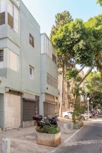een motorfiets geparkeerd voor een gebouw bij People LOVE this home! in Haifa