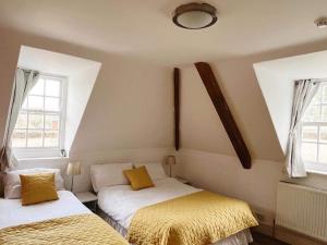 two beds in a room with two windows at 4 bed loft apartment overlooking historic town in Trowbridge