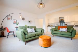 a living room with two green couches and a table at Victoria Apartment 2 in Torquay