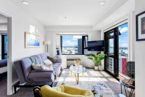 a living room with a couch and a table at 1BR with Stunning Harbour Views - Netflix - WiFi in Auckland