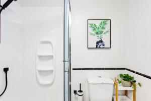 a bathroom with a shower stall and a toilet at 1BR with Stunning Harbour Views - Netflix - WiFi in Auckland +23 photos