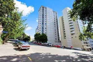 a street with two tall buildings and a parking lot at 1BR with Stunning Harbour Views - Netflix - WiFi in Auckland