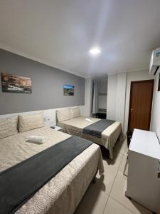 um quarto de hotel com duas camas e um sofá em POUSADA CECILIA em Canindé de São Francisco