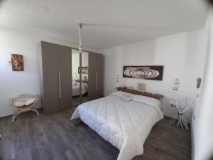 a bedroom with a large white bed in it at Casa Orchidea in Aggius