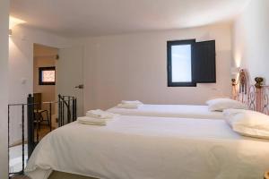 a bedroom with three beds with white sheets and a window at Casinha - Lusitália Eden in Sintra