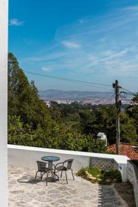 a table and two chairs sitting on a patio with a view at Casinha - Lusitália Eden in Sintra