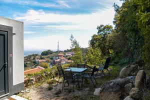 uma mesa e cadeiras sentadas no topo de uma colina em Casinha - Lusitália Eden em Sintra