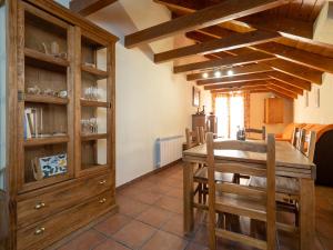 a dining room with a table and wooden cabinets at Apartamentos Ca de Marti in Bohí