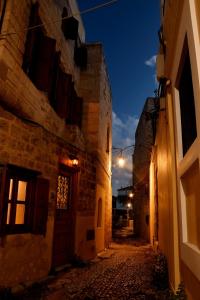 eine Gasse mit einem Gebäude und einer Tür in der Nacht in der Unterkunft The three story old town house in Rhodos (Stadt)