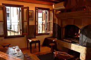 sala de estar con chimenea y mesa con copas de vino en The three story old town house en Rodas