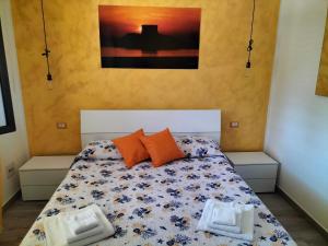 ein Schlafzimmer mit einem Bett mit orangefarbenen Kissen in der Unterkunft R&B mediterraneo in Bosa