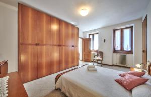 - une chambre avec un grand lit et un mur en bois dans l'établissement Casa Mocchetti, à Lezzeno