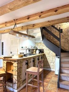 a kitchen with a stone fireplace and a table and chairs at Domek nad Śniardwami in Suchy Róg